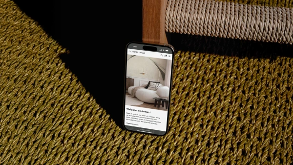 Telefon-mockup med Nordic Walls webbplats på skärmen.